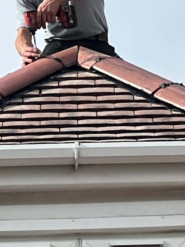 This is a photo of one of the operatives of Giltbrook Roofing Repairs installing new ridge tiles