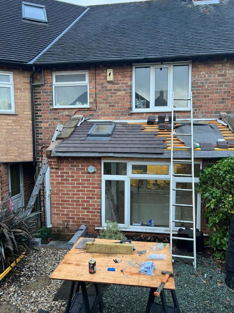 This is a photo of a roof extension that is having new roof tiles installed. This is a photo taken from the roof ridge looking down a tiled pitched roof on to a flat roof. Works carried out by Giltbrook Roofing Repairs